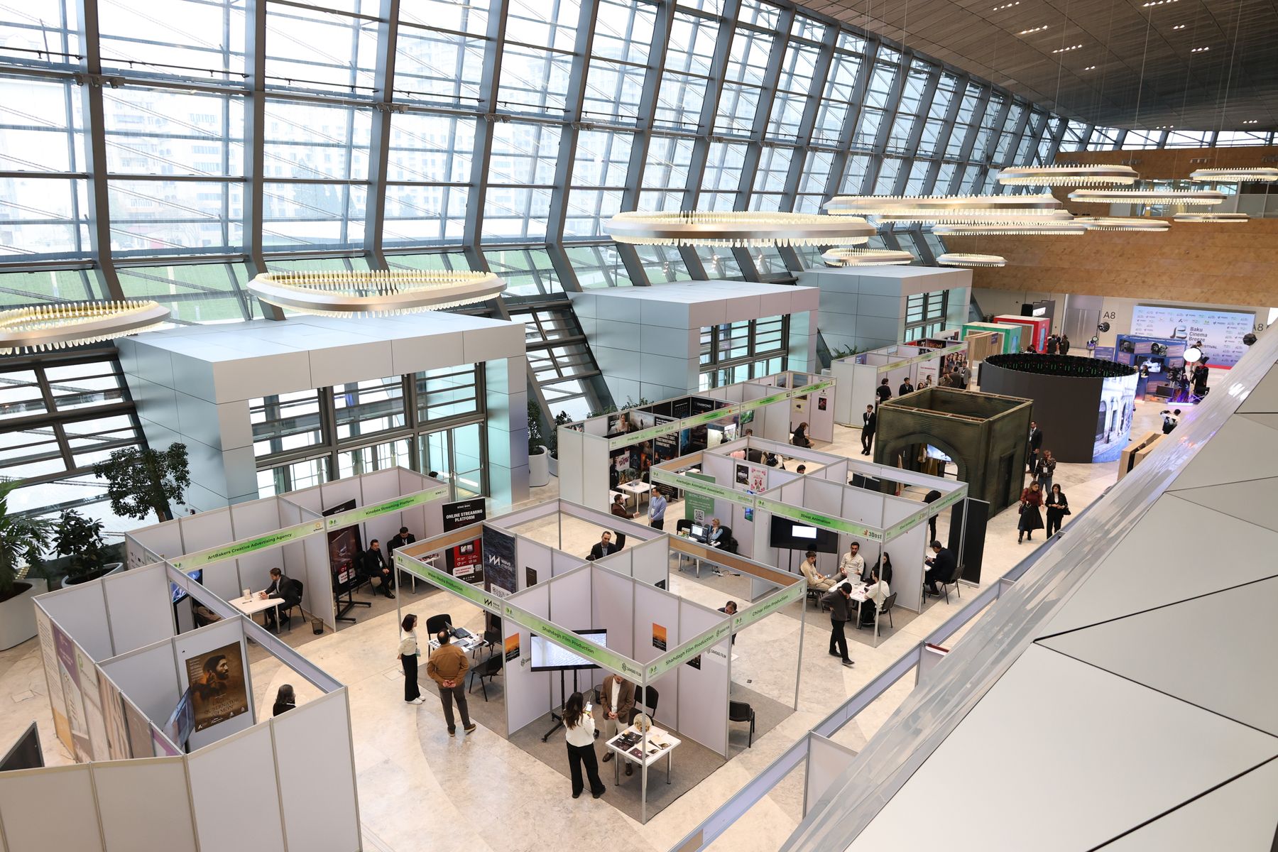 A busy trade show hall with stands and visitors
